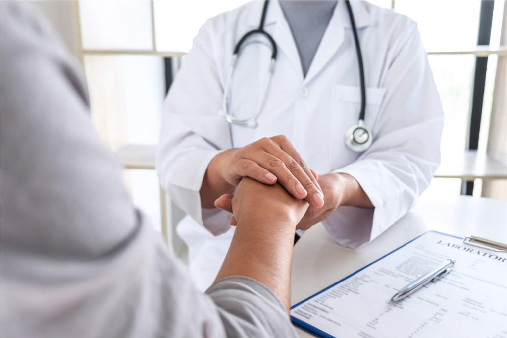 close up of doctor and patient holding hands
