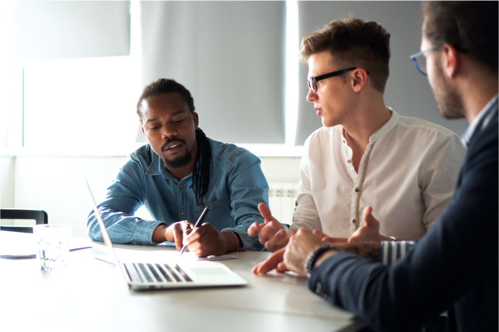 three men in a meeting with a computer