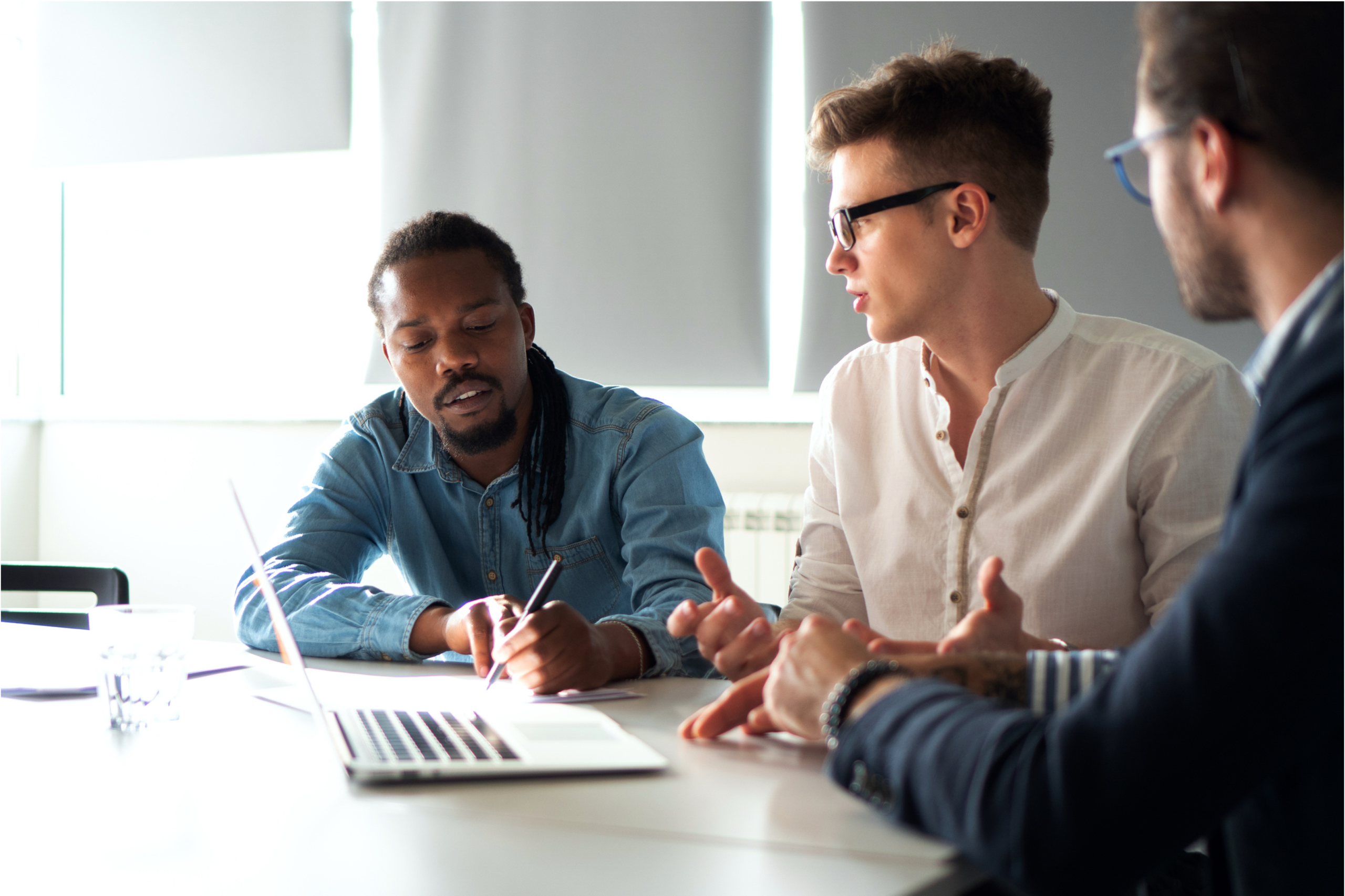 three men in a meeting with a computer