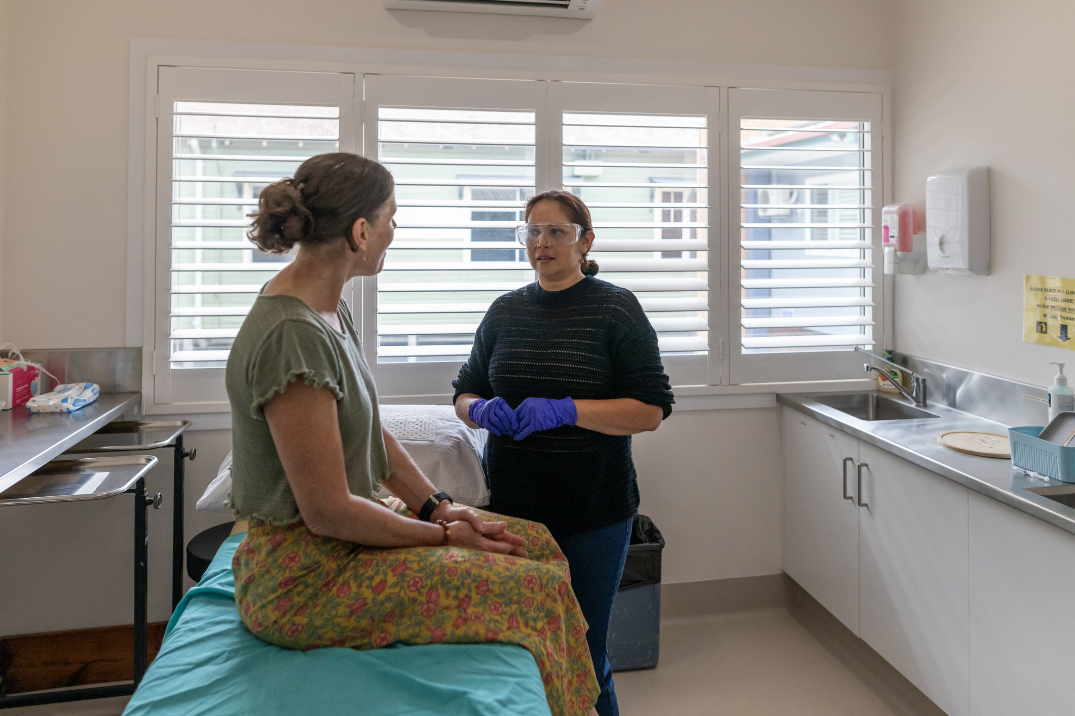 Woman receiving a vaccination injection from an Australian Aboriginal doctor in a modern medical clinic